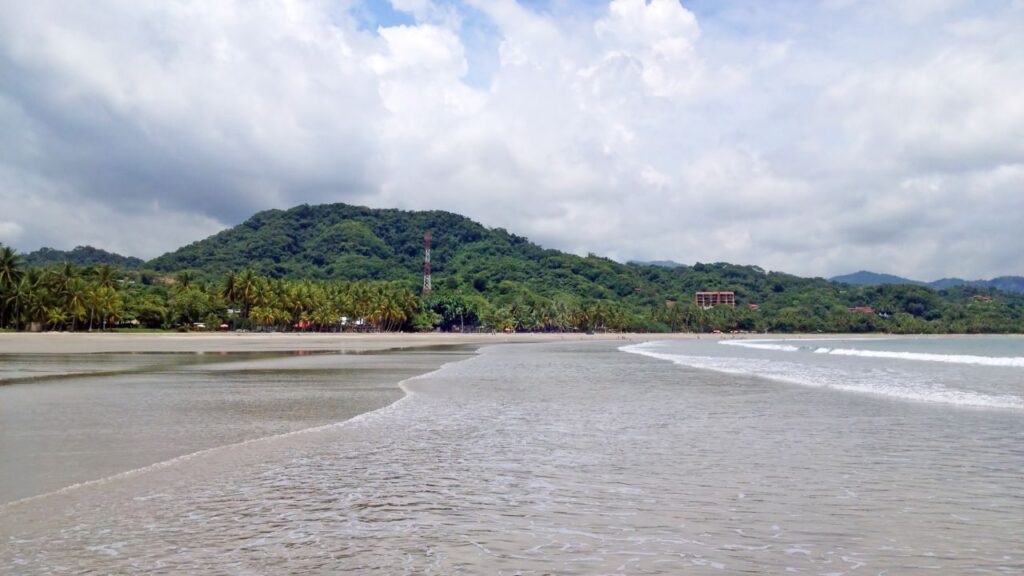 Expansive view of Samara Beach with its gentle waves, one of the best beaches in Costa Rica.