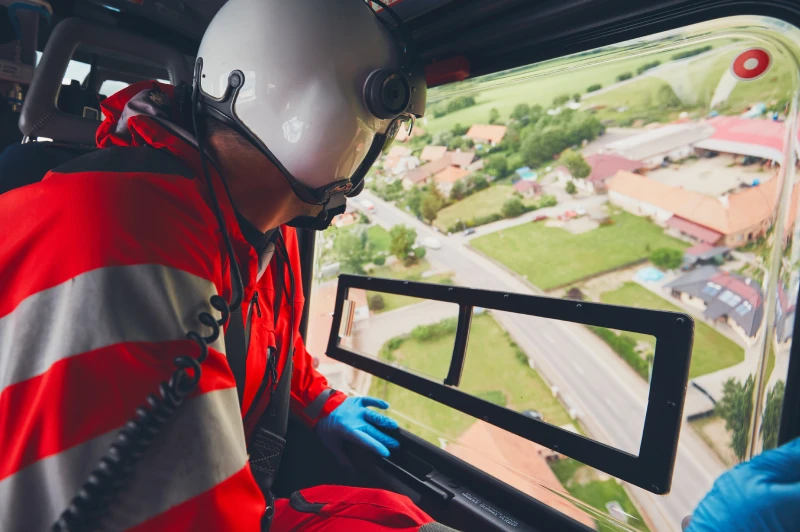 Emergency medical assistance from helicopter with rescue worker looking down