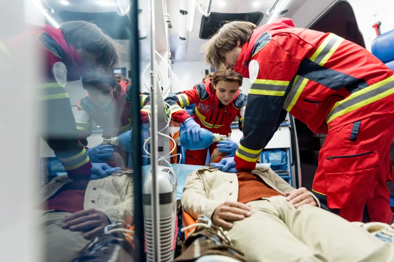 Emergency medical assistance team providing care in an ambulance